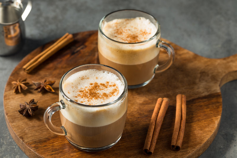 Two cups of chai tea latte topped with cinnamon